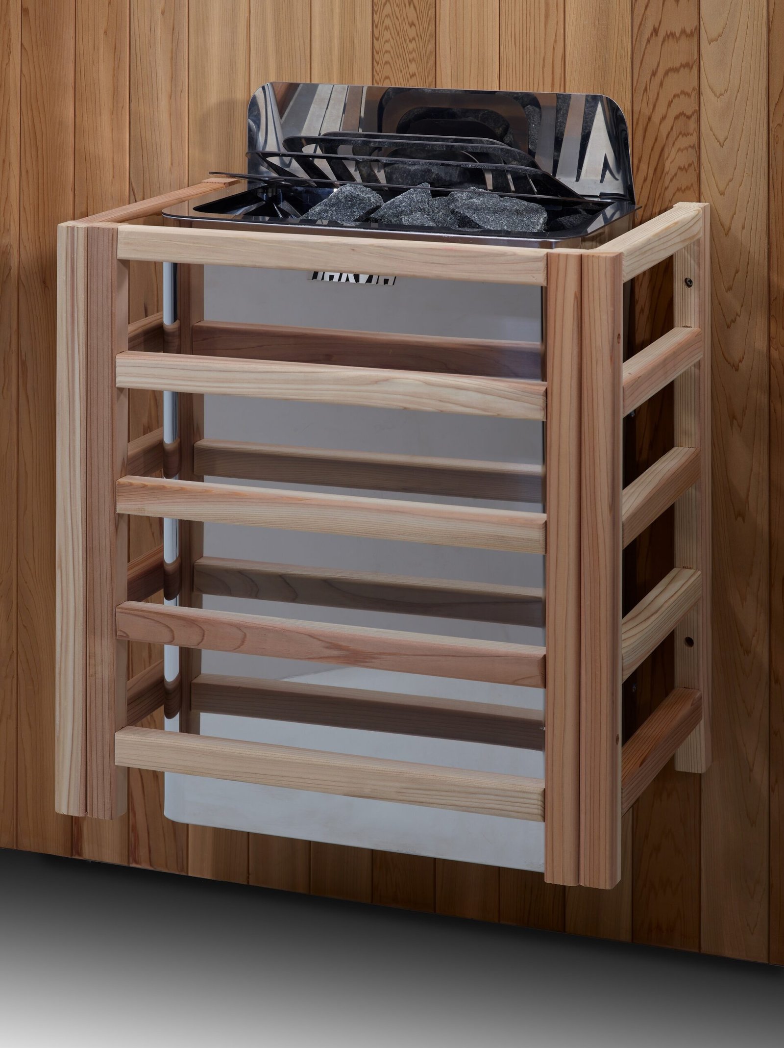 Harvia wall-mounted sauna heater with stone basket and wooden safety guard inside cedar sauna.