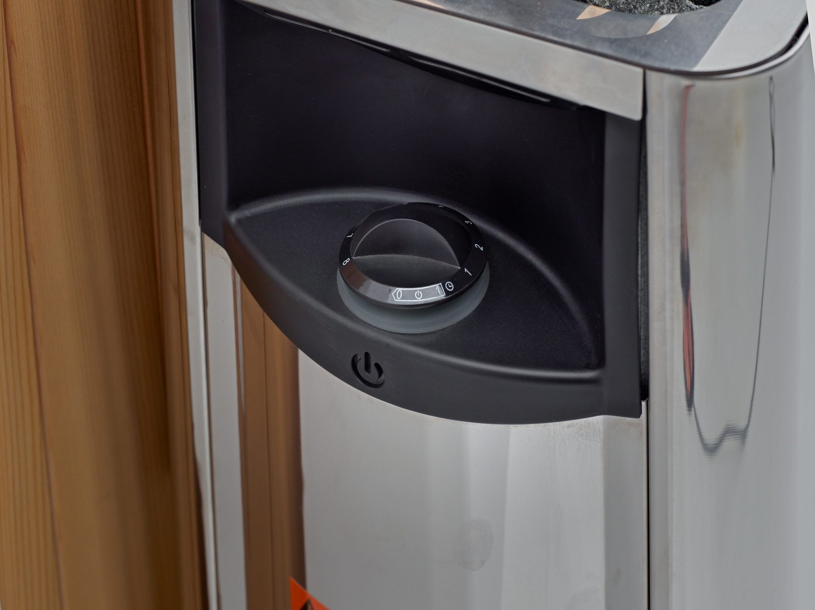 Harvia Wall sauna heater control dial close-up showing built-in temperature and timer settings.